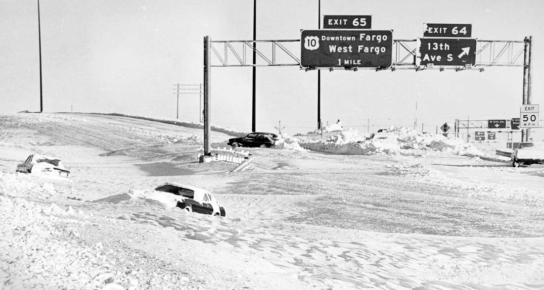 Image: a photograph from Colburn Hvidsten III showing several cars in a snowy ditch at the I-29 and 13th Avenue South interchange in Fargo. 