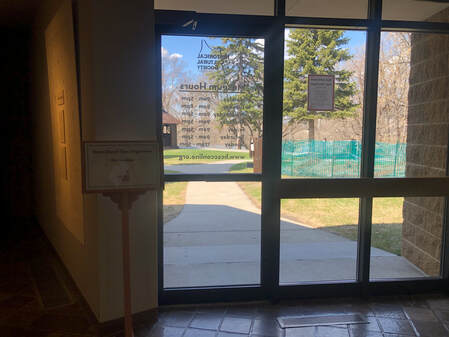 Interior photo of museum of glass door leading outside to Viking Ship Park and the replica Stave Church.